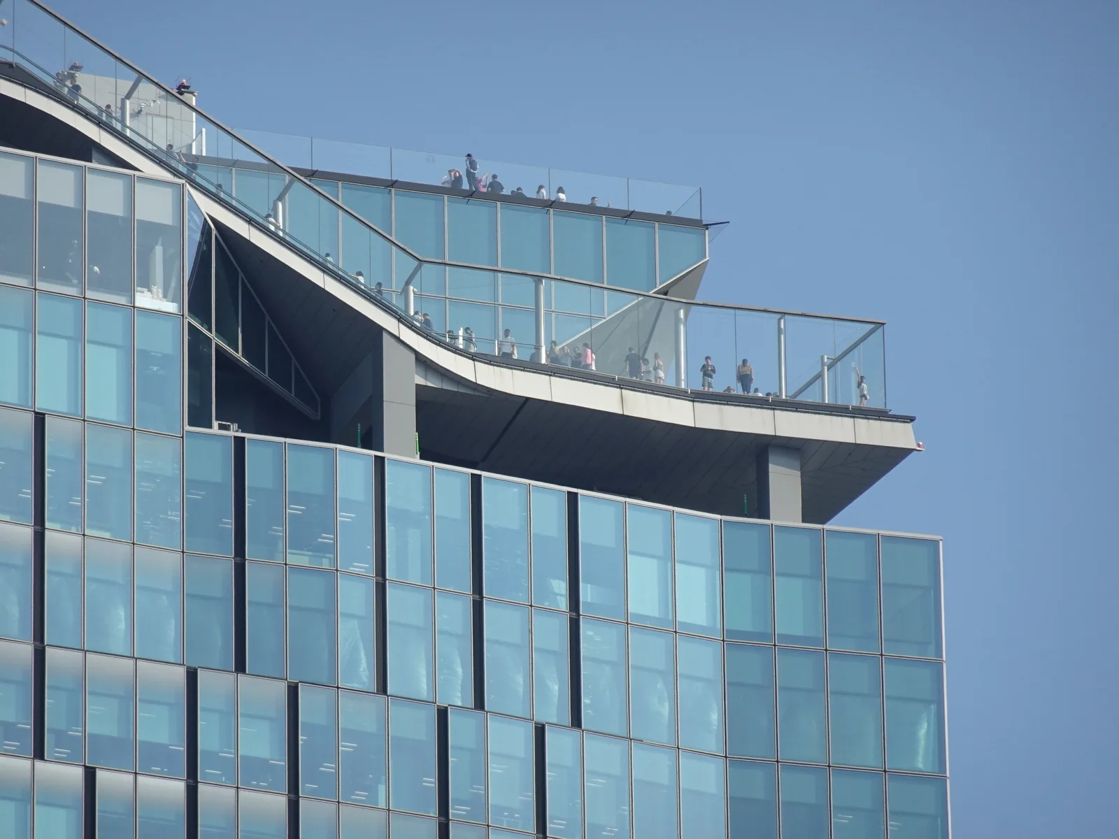 Visitors on the elevated terraces of Shibuya Sky, seen from Miyashita Park in Tokyo